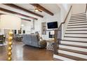 Open-concept living room with hardwood floors, fireplace, and elegant staircase at 114 Village Green Ave, Woodstock, GA 30189