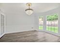Open living room with chandelier, wood floors and natural light at 125 Sandridge Ct, Alpharetta, GA 30022
