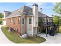 A multi-level deck with outdoor seating is adjacent to a brick and vinyl sided house and attached garage at 150 Rose Creek Dr, Covington, GA 30014
