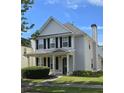Two-story home featuring gray siding, black shutters, a chimney, and a well-manicured lawn with green shrubs at 4677 Liberty Square Dr, Acworth, GA 30101