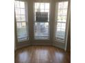 Sunlit living room with gleaming hardwood floors and large windows, offering a bright and airy space at 1843 Grove Way, Hampton, GA 30228