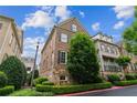 Beautiful brick exterior showcasing lush landscaping and mature trees in a desirable community at 2313 Saint Davids Nw Sq # 12, Kennesaw, GA 30152