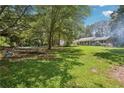 Large backyard with mature trees, green grass, and play structure for Gathering fun at 4825 Rollins Dr, Powder Springs, GA 30127