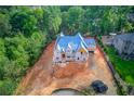 Aerial view of new home construction featuring blue roof, and wooded surroundings at 2808 Carson Garrett Ct, Buford, GA 30519