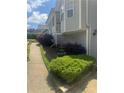 Two story gray home with lush landscaping, including a fountain and verdant foliage along a cozy side walkway at 72 Victorian Cir, Dallas, GA 30157