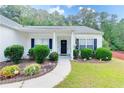 Inviting front entrance with manicured bushes and flowers along the walkway and a covered porch at 2221 Baker Carter Dr, Loganville, GA 30052