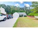 Traditional single-story home with a well-maintained lawn, attached garage, and long driveway with parked cars at 2221 Baker Carter Dr, Loganville, GA 30052