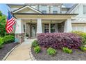 Charming front porch with brick columns and lush landscaping, featuring a welcoming American flag at 337 Spotted Ridge Cir, Woodstock, GA 30188