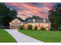A beautiful home exterior at sunset, featuring a brick facade, manicured lawn, and inviting curb appeal at 2702 Moorings Pkwy, Snellville, GA 30039
