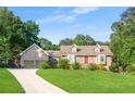 Charming brick home with a well-manicured lawn, dormer windows and a long driveway leading to a two-car garage at 2702 Moorings Pkwy, Snellville, GA 30039