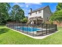 Backyard pool surrounded by a safety fence, deck, and green grass at 329 Kyles Cir, Hiram, GA 30141