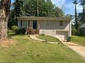 Home exterior featuring a grey brick facade, small front porch, and attached garage at 115 Delmoor Nw Dr, Atlanta, GA 30311