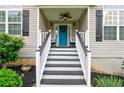 Inviting front porch with a blue door, seating, black and white accents, and a decorative wreath at 128 Champion Way, Hiram, GA 30141