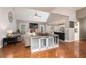 Open-concept living room featuring hardwood floors, modern decor, fireplace, and seamless kitchen access at 128 Champion Way, Hiram, GA 30141