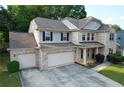 Charming two-story brick home with a three-car garage and manicured front yard at 139 Vinca Cir, Suwanee, GA 30024