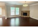 Bright living room featuring a stone fireplace, hardwood floors, and a large window with natural light at 139 Vinca Cir, Suwanee, GA 30024