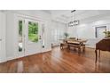 Bright dining room featuring hardwood floors, a farmhouse table, and natural light from the door at 2945 Ashbyrn Ct, Buford, GA 30519