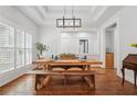 Bright dining room featuring hardwood floors, farmhouse table, modern lighting fixture at 2945 Ashbyrn Ct, Buford, GA 30519