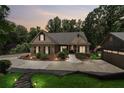 Twilight view of home showcasing stone accents, manicured landscaping, and an inviting driveway at 2945 Ashbyrn Ct, Buford, GA 30519