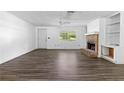 Spacious living room with a brick fireplace, large window, and modern wood-look flooring at 315 Pleasant Grove Rd, Mcdonough, GA 30252