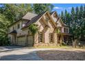 Beautiful two-story stone and brick home featuring a front porch and attached garage at 3809 Wieuca Ne Rd, Atlanta, GA 30342