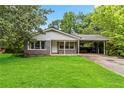 Well-maintained single-story home with a lush green lawn and gray brick facade at 1176 Cardinal Ne Rd, Conyers, GA 30012