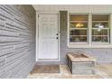 Close-up of the front door with gray brick facade and a small planter box at 1176 Cardinal Ne Rd, Conyers, GA 30012