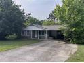 Lovely single-story home featuring a covered parking area, a neat front yard, and beautiful surrounding trees at 1176 Cardinal Ne Rd, Conyers, GA 30012