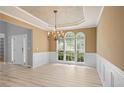 Bright dining room featuring elegant wainscoting, tray ceiling, and large windows at 2595 Glaramara Ter, Cumming, GA 30041