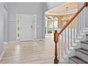 Inviting foyer with wood-look tile flooring, stairs, and a view of the dining room at 2595 Glaramara Ter, Cumming, GA 30041
