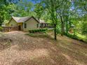 Scenic backyard featuring a lush lawn, mature trees, and a charming wooden fence at 5535 Dorsett Shoals Rd, Douglasville, GA 30135