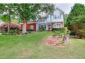 Well-maintained front yard of a two-story home featuring lovely landscaping and mature trees at 662 Shady Willow Ln, Loganville, GA 30052