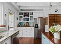 Well-lit kitchen with stainless steel refrigerator, granite countertops, wood floors and ample storage space at 1691 Whitlock Rd, Marietta, GA 30066