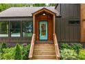 Inviting front entrance featuring a bright blue door and wooden steps, surrounded by lush landscaping at 2001 Swazey Dr, Decatur, GA 30032