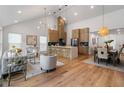 Open-concept living space flows into the kitchen and dining area, featuring hardwood floors and modern lighting at 2001 Swazey Dr, Decatur, GA 30032