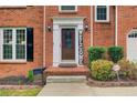 Close-up of the front door with brick entryway, decorative sidelights, and 'Welcome' sign at 1360 Stampmill Way, Lawrenceville, GA 30043