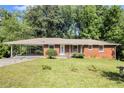 Charming brick ranch-style home with covered carport and a well-manicured front lawn at 3055 Henderson Mill Rd, Atlanta, GA 30341