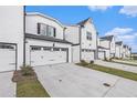 A row of townhouses with white exteriors, attached garages, concrete driveways, and neatly landscaped lawns at 1704 Hyssop Se Blvd, Smyrna, GA 30126