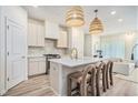Bright, modern kitchen with island, stylish pendant lighting, white countertops, and a seamless flow into the living area at 1704 Hyssop Se Blvd, Smyrna, GA 30126