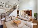 Staged living room with high ceilings, staircase and neutral decor creating a bright and airy space at 2577 Ozella Sw Pl, Atlanta, GA 30331