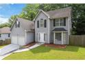 Traditional two-story home featuring a two-car garage, fenced yard, and manicured lawn at 2907 Oakvale Falls Dr, Decatur, GA 30034