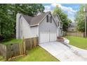View of the home showing the driveway leading to a two-car garage and fenced yard at 2907 Oakvale Falls Dr, Decatur, GA 30034