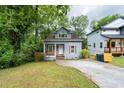 Quaint home with well-manicured lawn, wood accents, blue exterior, and private driveway at 3111 Jones St, East Point, GA 30344
