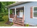 Inviting front porch with decorative columns and warm wood accents for relaxing outdoors at 3111 Jones St, East Point, GA 30344