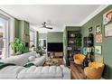 This modern living room showcases a green accent wall, stylish furniture, plants and a large window at 57 Forsyth Nw St # 11G, Atlanta, GA 30303