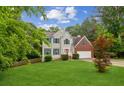 Beautiful two-story home featuring manicured lawn, grey siding, brick details, and inviting curb appeal at 111 Trellis Ct, Acworth, GA 30101