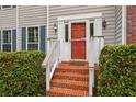 Inviting front entrance with brick steps, red door, and manicured hedges at 111 Trellis Ct, Acworth, GA 30101