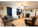 Cozy living room with carpeted floors, ceiling fan, and natural light from the window at 361 N Dogwood N Ave, Social Circle, GA 30025