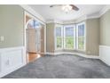 Sunlit dining room with bay window, crown molding, and neutral gray carpet at 3641 Mountain Cove Rd, Snellville, GA 30039