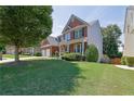 Charming home with manicured lawn, lush trees, and a welcoming entrance at 590 Kyle Trace Ct, Sugar Hill, GA 30518